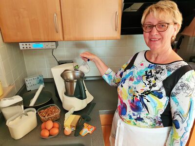 Frau mit Backzutaten und -utensilien beim Kuchenbacken