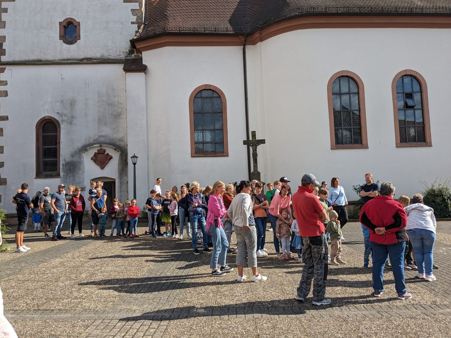 Lange Schlange von Menschen allen Alters vor einem Kirchengebäude