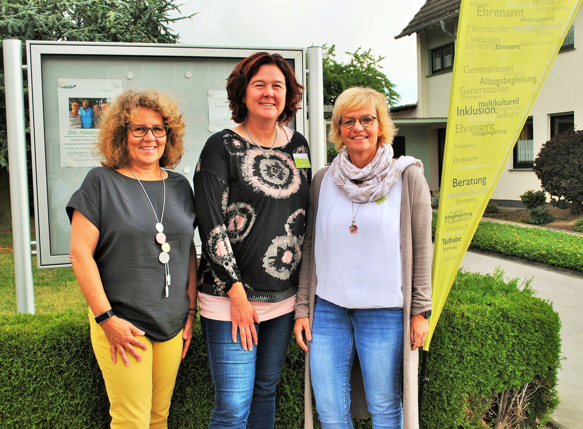 Gruppenbild mit drei Frauen und Aufsteller