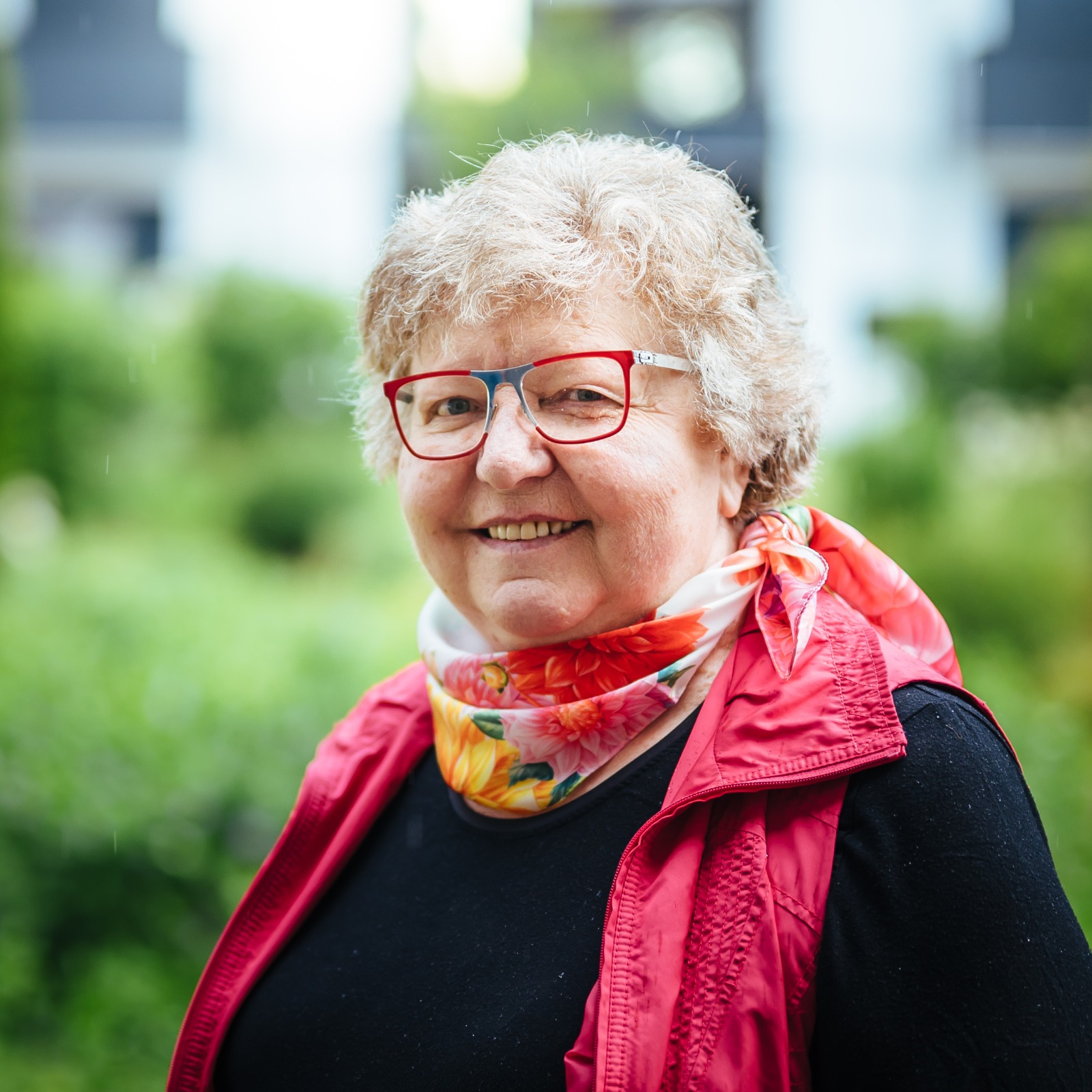 Roswitha Herres Roswitha Herres mit roter Brille und blumigem Schal, Porträt im Grünen