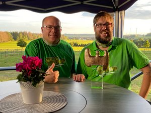 Bj&ouml;rn Flick (links) und Christian D&ouml;ring vom Verein „W&auml;ller helfen" mit dem SWR-Ehrenamtspreis 2020 am Tisch im Freien