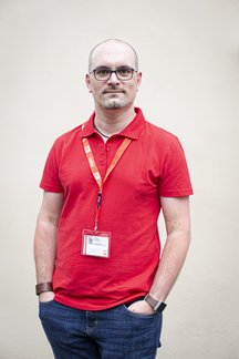 A. Wagner in rotem Polo-Shirt mit Lanyard, Portr&auml;t